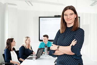 A young colleague from IT Purchasing looks into the camera and shows that career entry via IT Purchasing jobs works well.