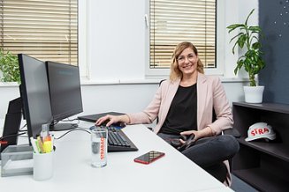 Marion, IT software developer at STRABAG, sitting at her desk in the office