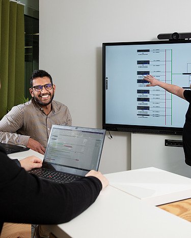 Three IT experts in a meeting room.