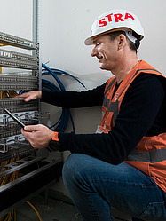 Two IT specialists check network cabling in a building shell.