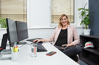 Marion, IT-Softwareentwicklerin bei STRABAG Marion, IT-Softwareentwicklerin bei STRABAG, an ihrem Schreibtisch sitzend im Büro