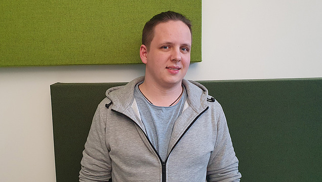 A young man looks into the camera.