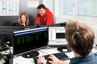 Kolleg:innen der Softwareentwicklung arbeiten an Softwareentwicklungsprozessen und dem eigenentwickelten ERP-System.