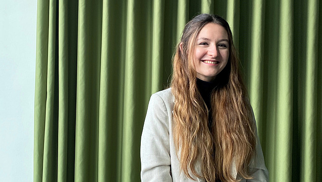 A young woman with long hair smiles at the camera.