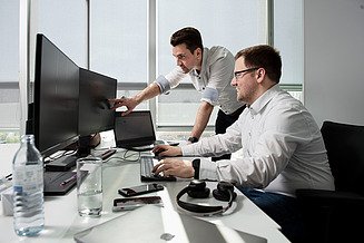 Zwei Kollegen der Softwareentwicklung bearbeiten im Rahmen ihrer Tätigkeit in der Softwareentwicklung Aufgaben aller Art.