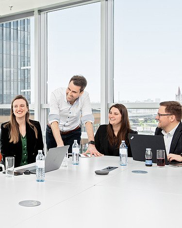 Ein IT Professional diskutiert mit seinem Team in einem Meetingraum